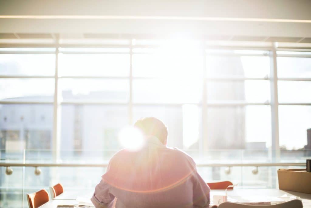 insurance-support (8) Man working at a desk by a window with the sun coming in