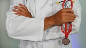 online-marketing-hIgeoQjS_iE-unsplash A man in a white coat holding a stethoscope