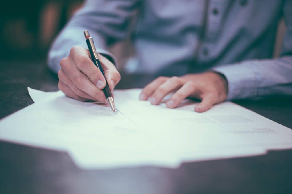 scott-graham-OQMZwNd3ThU-unsplash man writing on paper